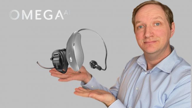 Man vor grauem Hintergrund zeigt eine Starkey Omega AI CIC und RIC