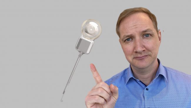 Mann zeigt mit dem Finger auf ein Implantat.